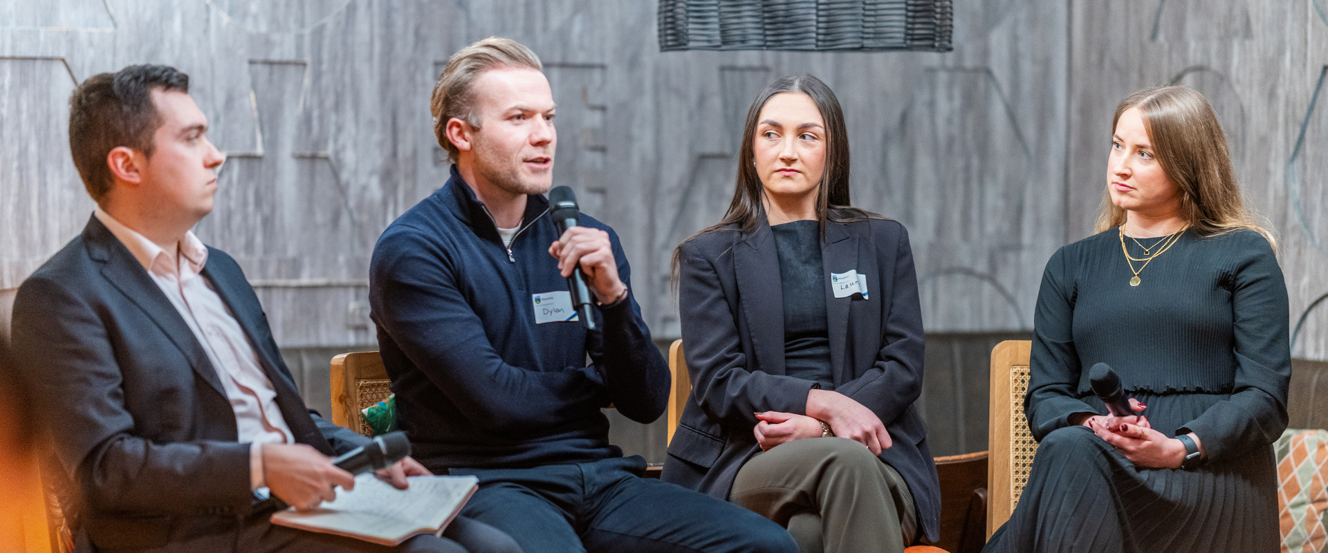 Four UCD alumni speaking on a panel at a global event.